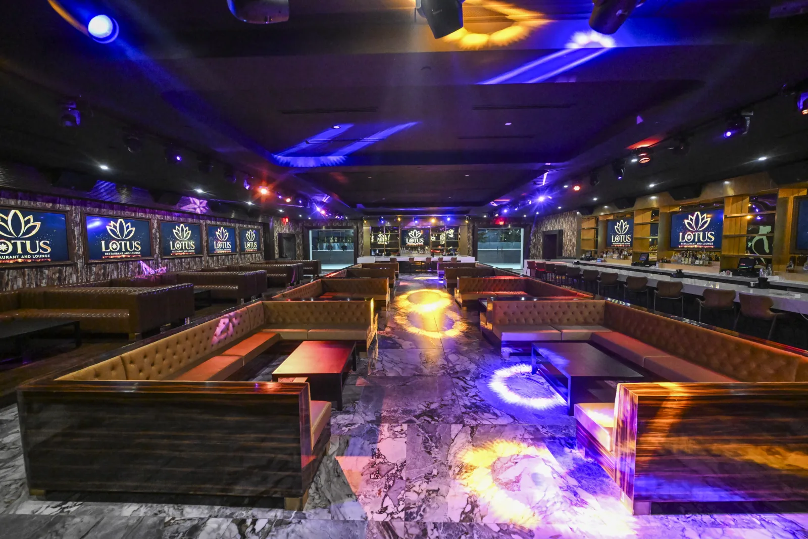 The main room, marble floor lit with rings of light, bar along the right.