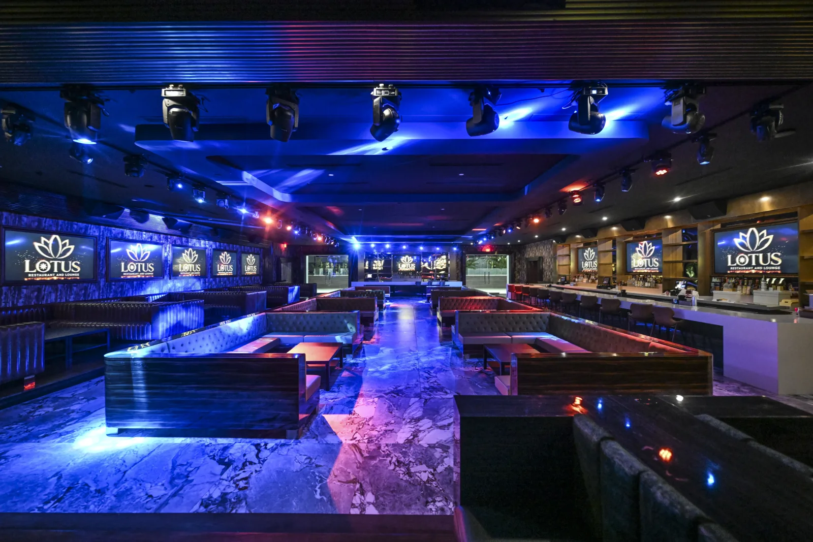The main room bathed in blue, booth seating lining the marble floor.